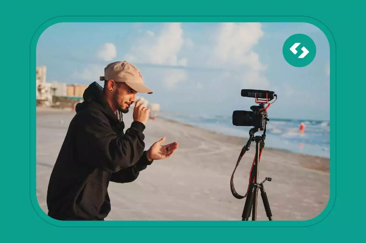 Homem com camera, na praia, produzindo conteudo de video para seu canal no youtube