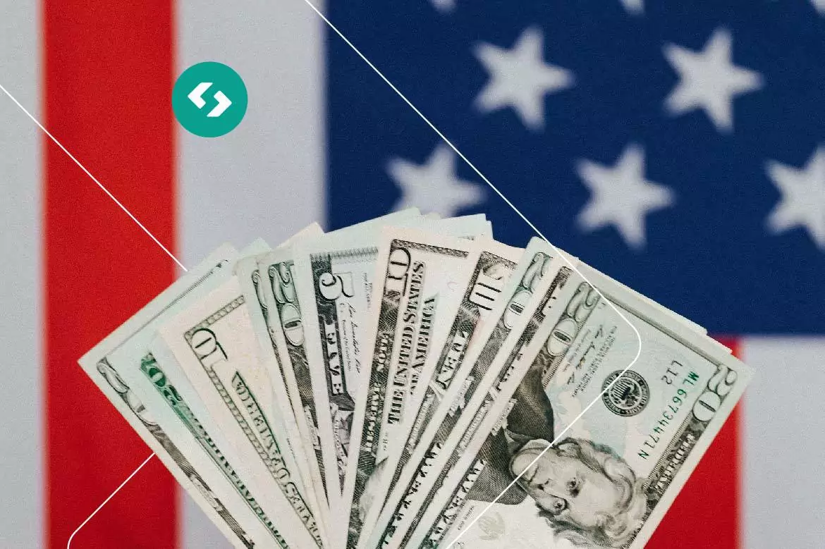 Notas de dólares americados e ao fundo bandeira dos Estados Unidos